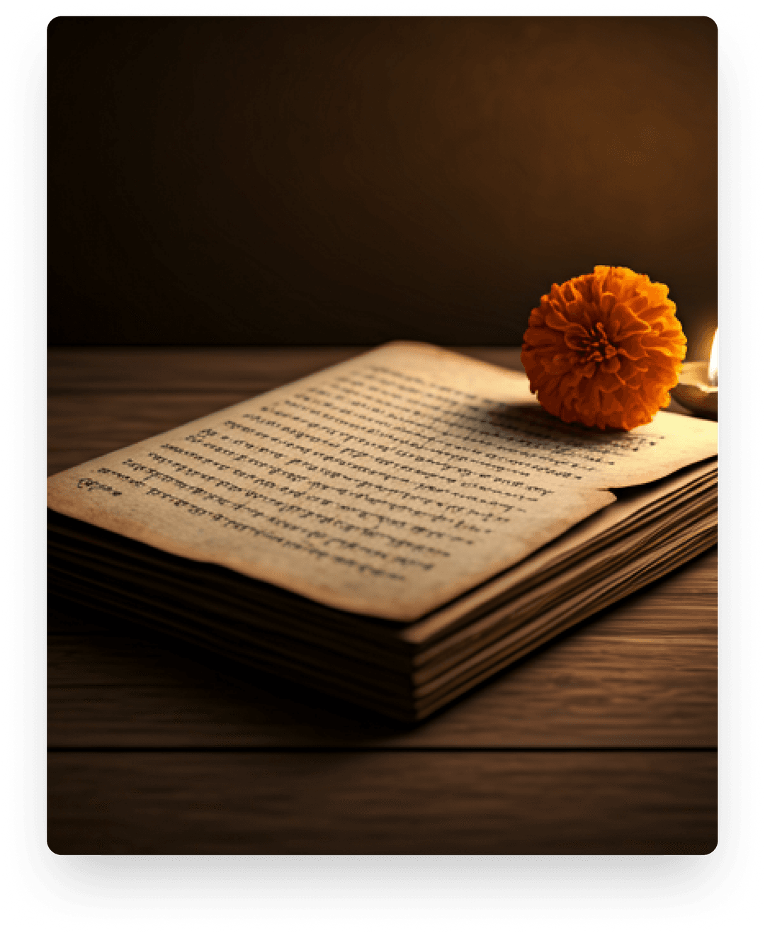 An open antique book resting on a wooden table beside a dried flower